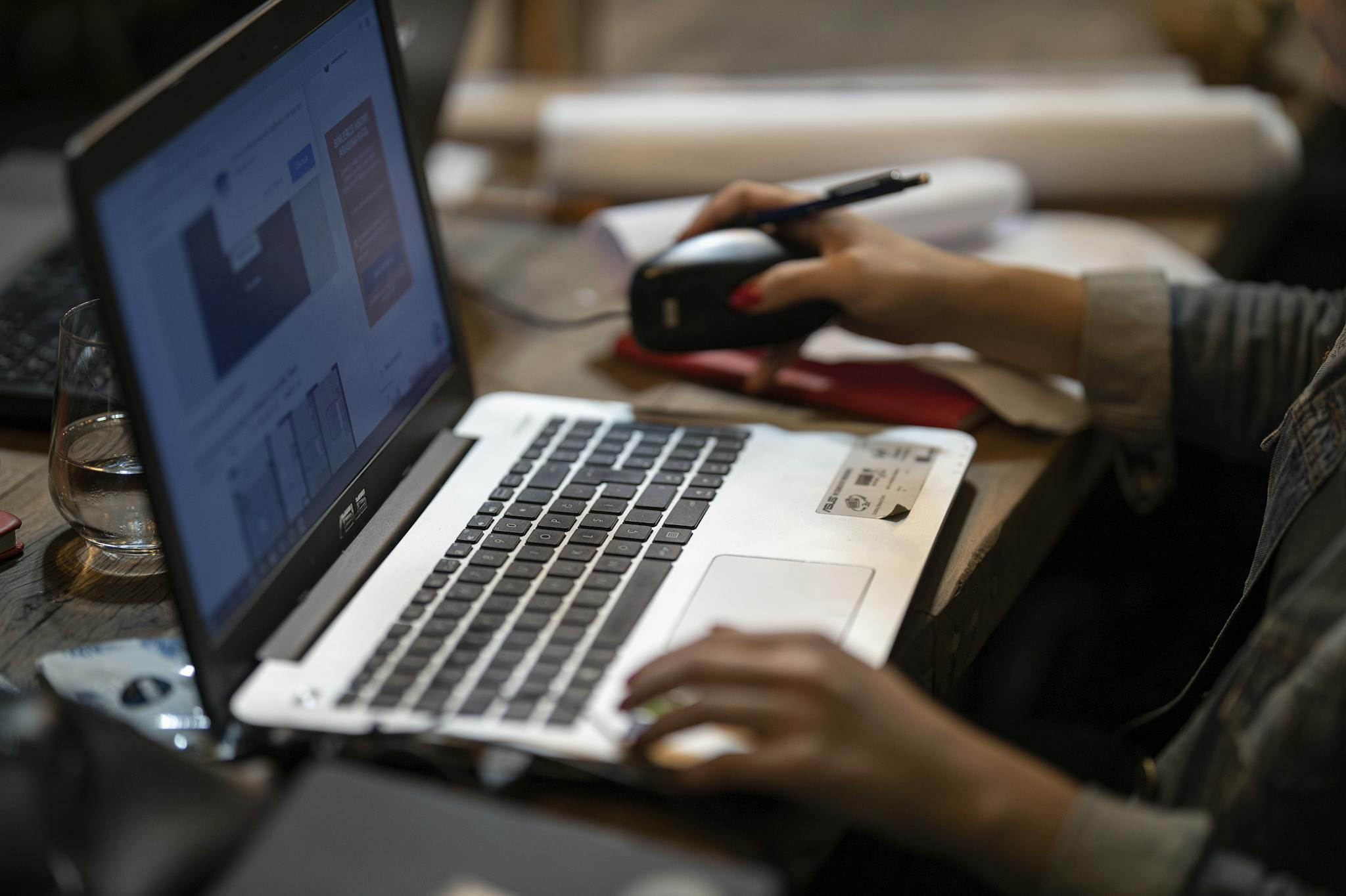 Close-up of hands using a laptop in a cozy indoor workspace, ideal for remote work and digital nomads.